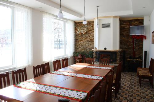 a dining room with two tables and a fireplace at Atanasovata Kashta in Govedartsi