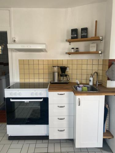 a kitchen with a white stove and a sink at Spirit Gästis in Ekeby