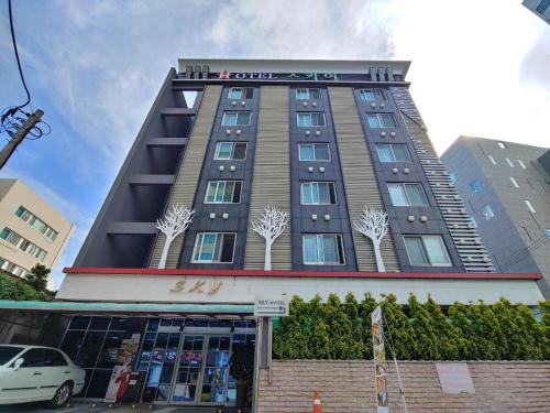 a tall building with a sign on top of it at SKY Hotel in Changwon