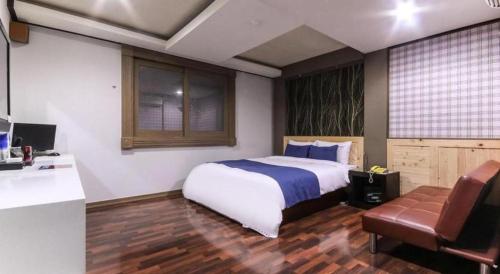 a bedroom with a large bed and a kitchen at SKY Hotel in Changwon