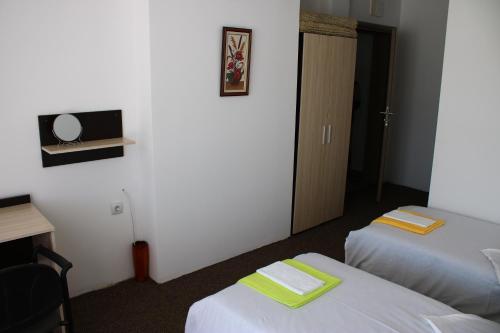 a hotel room with two beds and a television at Atanasovata Kashta in Govedartsi