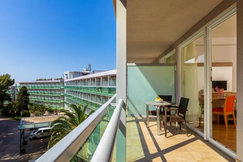 a balcony with a table and chairs on a building at Hotel Aurora in Mali Lošinj
