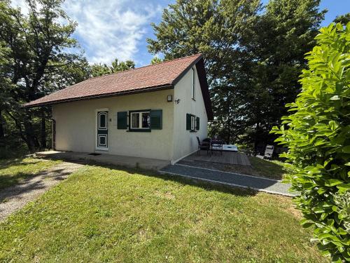a small white house in a yard with trees at Weinblick Kitzeck in Kitzeck im Sausal