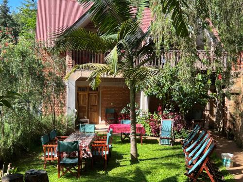 a patio with a table and chairs and a palm tree at David Crater Homestay in Lushoto