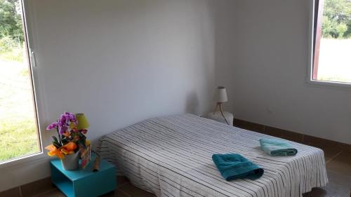 a bedroom with a bed with two towels on it at Maison bois à la campagne in Marnay