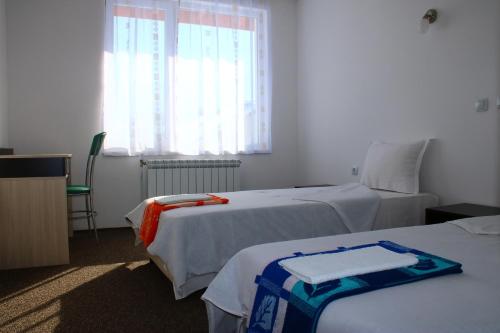 a hotel room with two beds and a window at Atanasovata Kashta in Govedartsi