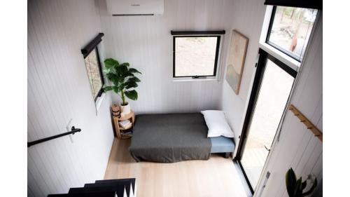 Habitación pequeña con cama en una casa pequeña en Tintenbar Riverfront Farmstay by Tiny Away, en Glenwilliam