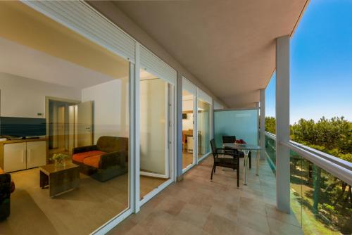 a living room with glass walls and a balcony at Hotel Aurora in Mali Lošinj