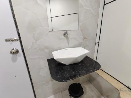 a white bathroom with a sink on a counter at Hotel MARUTI R Drive Inn Road in Ahmedabad