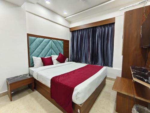 a bedroom with a large bed and a window at Hotel MARUTI R Drive Inn Road in Ahmedabad