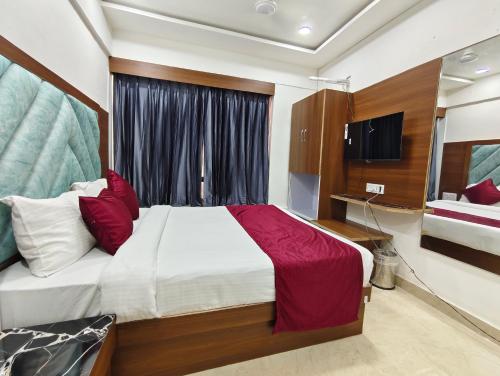 a bedroom with a large bed and a television at Hotel MARUTI R Drive Inn Road in Ahmedabad
