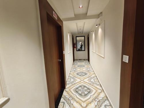a hallway with a tile floor in a hotel room at Hotel MARUTI R Drive Inn Road in Ahmedabad