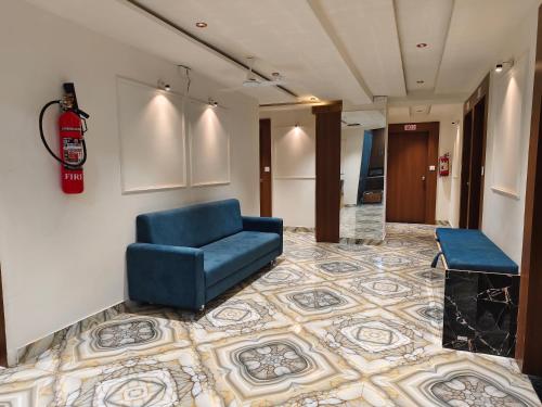 a waiting room with a blue chair and a floor at Hotel MARUTI R Drive Inn Road in Ahmedabad