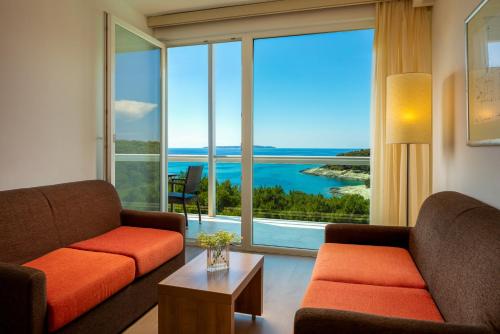 a living room with two couches and a large window at Hotel Aurora in Mali Lošinj