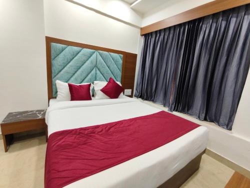 a bedroom with a large bed and a window at Hotel MARUTI R Drive Inn Road in Ahmedabad