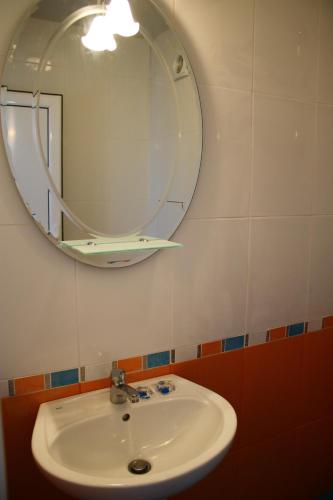 a bathroom with a sink and a mirror at Atanasovata Kashta in Govedartsi