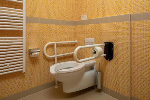 a bathroom with a toilet in a public restroom at Hotel Aurora in Mali Lošinj