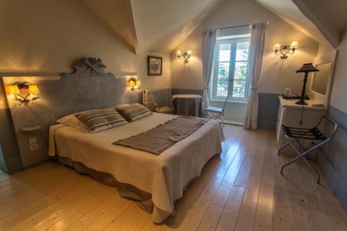 une chambre avec un grand lit et une fenêtre dans l'établissement La Villa des Charmilles, à Vernoux-en-Vivarais