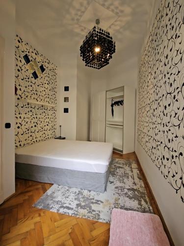 a bedroom with a large white bed and a chandelier at Phoenix Apartment in Budapest