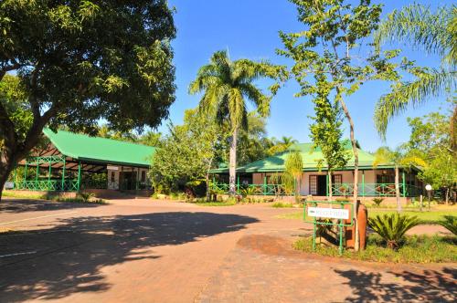 a building with a green roof in a park at Tzaneen Country Lodge in Tzaneen