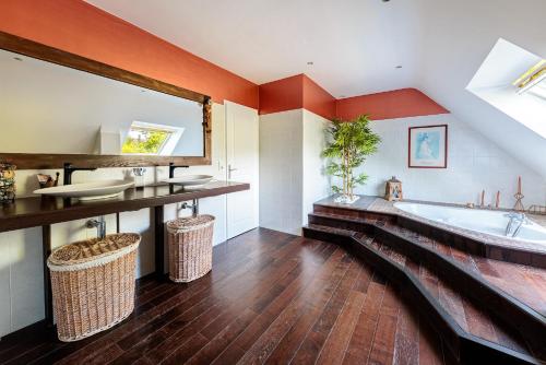 ein Badezimmer mit großer Badewanne und Waschbecken in der Unterkunft Villa Markaly in Vigneux-de-Bretagne