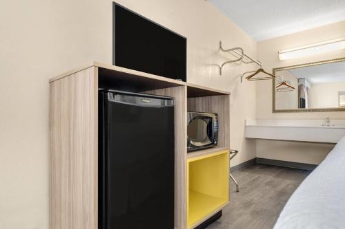 ein schwarzer Kühlschrank in einem Schrank mit einem Fernseher in der Unterkunft Days Inn by Wyndham Fort Wayne in Fort Wayne