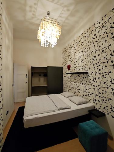 a bedroom with a bed and a chandelier at Phoenix Apartment in Budapest