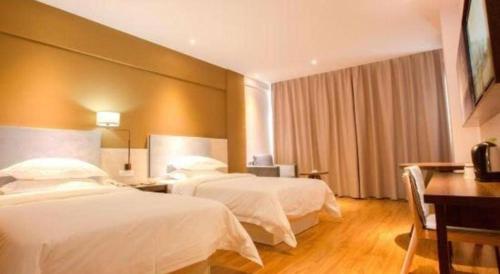 a hotel room with two beds and a desk at JTOUR Inn Guilin Two Rivers and Four Lakes Walmart in Guilin
