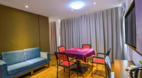 a living room with a couch and a table and chairs at JTOUR Inn Guilin Two Rivers and Four Lakes Walmart in Guilin