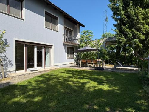 a house with a lawn and a table with an umbrella at Weinblick Kitzeck in Kitzeck im Sausal