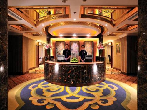a lobby with two men standing at a reception desk at Hohhot Inner Mongolia Hotel in Hohhot