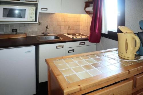 une cuisine avec un évier et un plan de travail dans l'établissement Résidence Le Cairn - STUDIO 4 PERSONNES CENTRE STATION MAE-3821, aux Orres