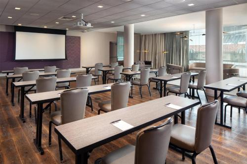 a conference room with tables and chairs and a screen at Andaz West Hollywood, By Hyatt in Los Angeles