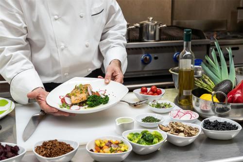 a chef holding a plate of food on a counter at Hyatt Regency Boston in Boston