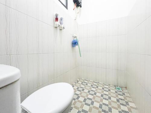 a bathroom with a toilet and a shower with a floor at Bilqis Homestay Syariah Mitra RedDoorz in Wonosobo