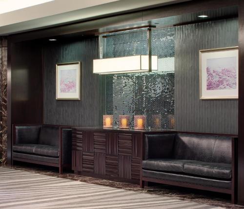 a lobby with black leather chairs and a bar at Hyatt Regency Boston in Boston
