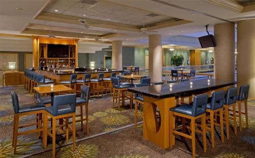 a restaurant with tables and chairs and a bar at Hyatt Regency Orlando International Airport Hotel in Orlando