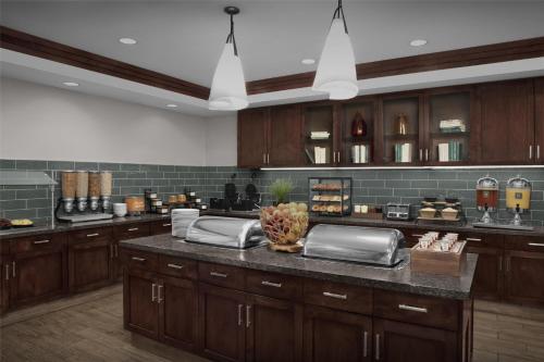 a large kitchen with wooden cabinets and a counter top at Homewood Suites by Hilton Oklahoma City-Bricktown in Oklahoma City
