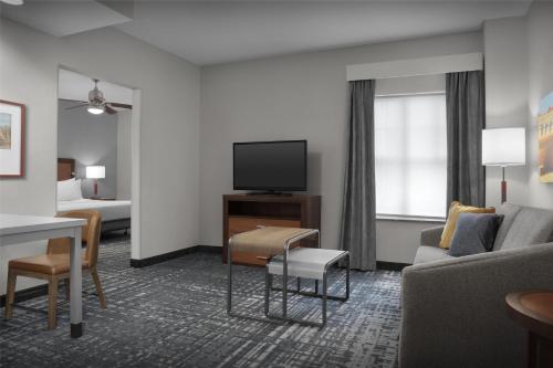 a hotel room with a couch and a tv at Homewood Suites by Hilton Oklahoma City-Bricktown in Oklahoma City