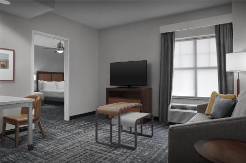 a hotel room with a couch and a tv at Homewood Suites by Hilton Oklahoma City-Bricktown in Oklahoma City