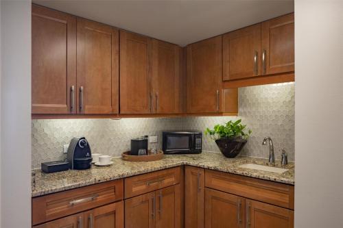 a kitchen with wooden cabinets and a sink and a microwave at Hyatt Regency Orlando International Airport Hotel in Orlando