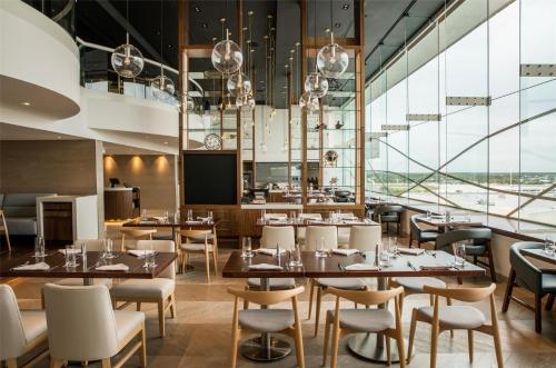 a restaurant with tables and chairs and large windows at Hyatt Regency Orlando International Airport Hotel in Orlando