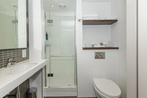 a bathroom with a shower and a toilet and a sink at DoubleTree by Hilton Hotel London - Tower of London in London