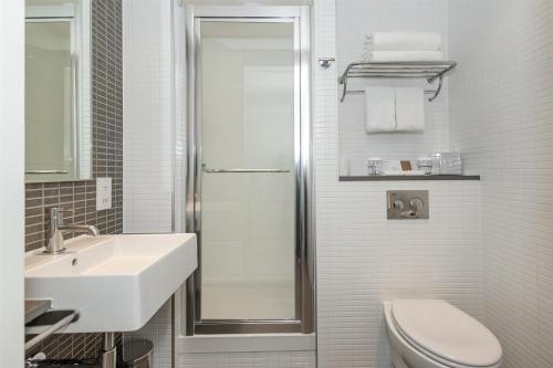 a bathroom with a shower and a toilet and a sink at DoubleTree by Hilton Hotel London - Tower of London in London