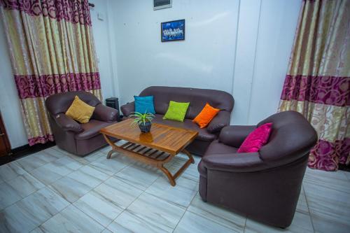 a living room with two couches and a coffee table at Sanda Villa Kosgoda in Kosgoda