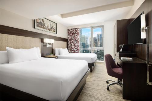a hotel room with two beds and a window at Hilton Garden Inn New York - Times Square Central in New York