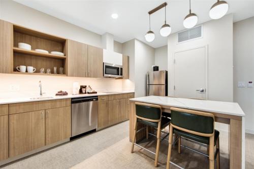 a kitchen with wooden cabinets and a kitchen island with chairs at Homewood Suites by Hilton East Rutherford - Meadowlands, NJ in East Rutherford