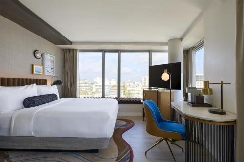a hotel room with a bed and a desk and a window at Hyatt Centric South Beach Miami in Miami Beach
