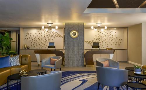 a lobby with a waiting area with chairs and tables at Hyatt Centric South Beach Miami in Miami Beach