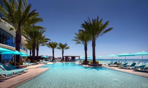 a large swimming pool with palm trees and chairs at Opal Sands in Clearwater Beach